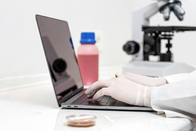 scientist working on laptop searching for vaccine.