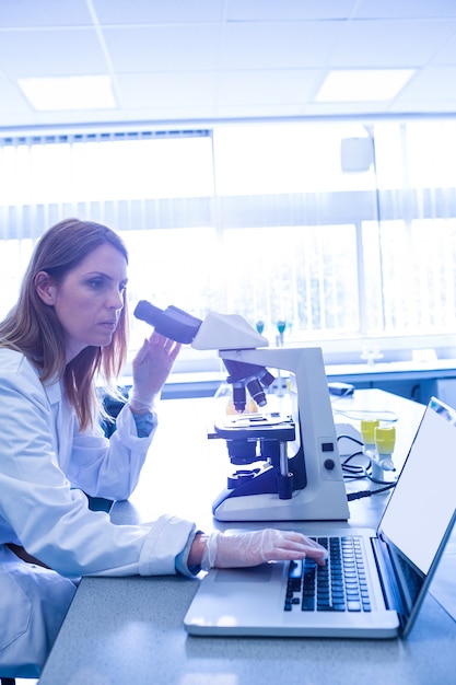 Scientist working with a microscope in laboratory