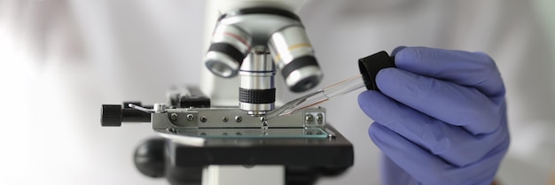 研究室科学技術と研究でピペットと微鏡を使う科学者