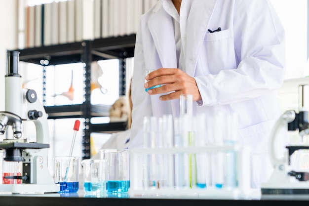 Scientists holding test tube while doing experimenting in the science room