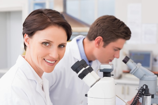 Scientists looking attentively in microscopes