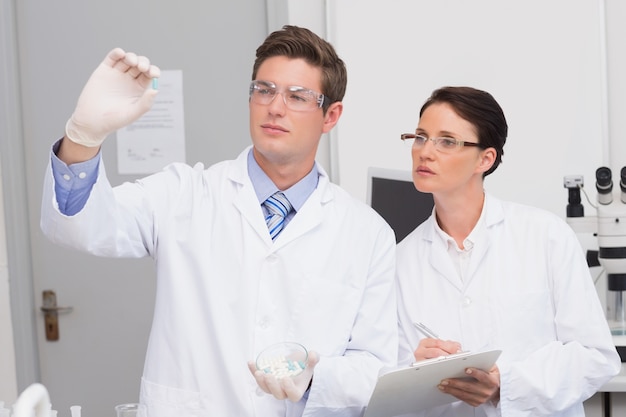 Scientists looking attentively at pill