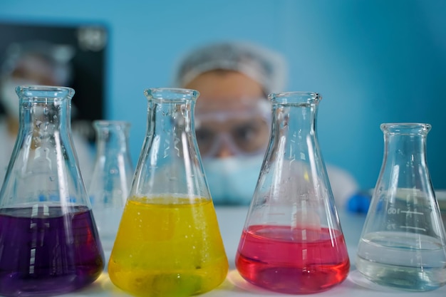 科学者は、代替のハーブ薬スキンケア美容製品を作るために、ガラス製品の植物ベースの薬の自然有機抽出と科学を研究しています研究所のコンセプトと開発