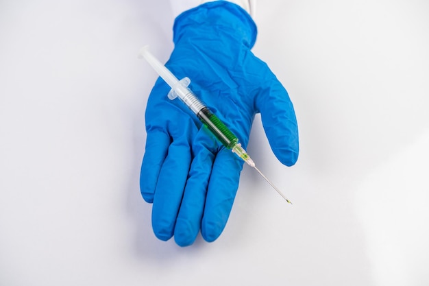 Photo scientists wearing masks and gloves holding a syringe with a vaccine to prevent covic19