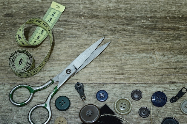 Scissors and buttons on a wooden background