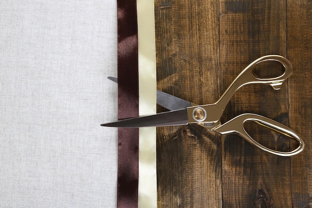 Scissors and color fabric on wooden background