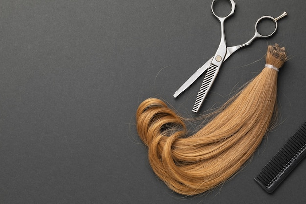 Scissors a comb and a cut strand of blond female baby hair