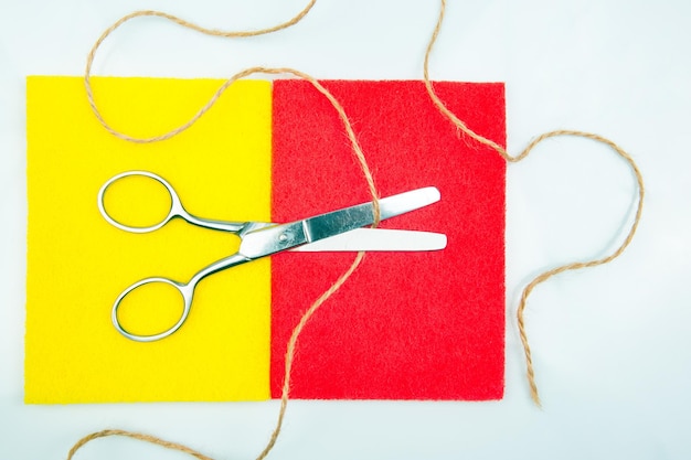 Scissors cut out a sample of colored material on a white background