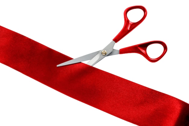 Scissors cut red silk ribbon on white background