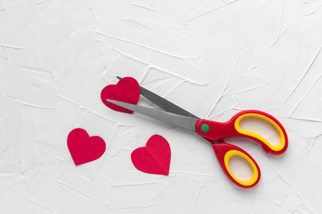 Scissors cutting red heart. Heartbreak, divorce, love pain concept. Valentine's day.