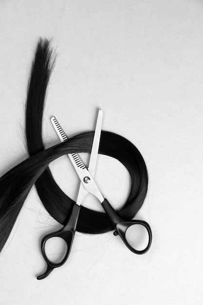 Photo scissors and hair on gray background