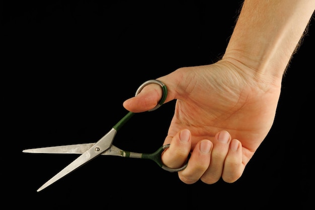 Scissors in hand on a black background