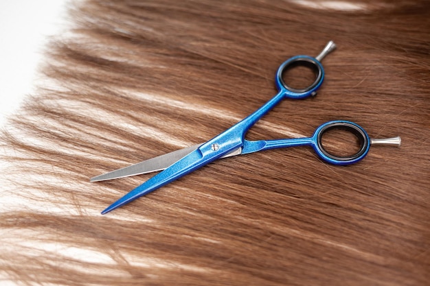Foto le forbici giacciono sul nastro dei capelli per l'estensione a casa estensioni dei capelli per ispessire le tue