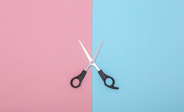 Scissors on pink blue background. Top view.