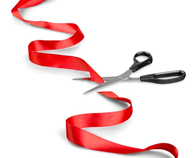 Scissors and red ribbon on a white background