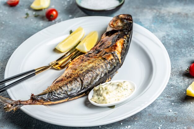 Scomber roast, baked mackerel fish with lemon and sauce. Japan dish, top view.