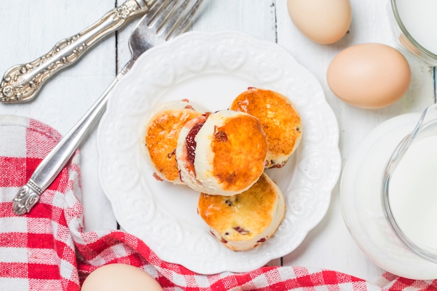 Scones, Scones с джемом и чаем с молоком крупным планом на столе