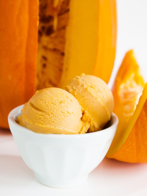 Scoop of gourmet pumpkin gelato in white bowl.