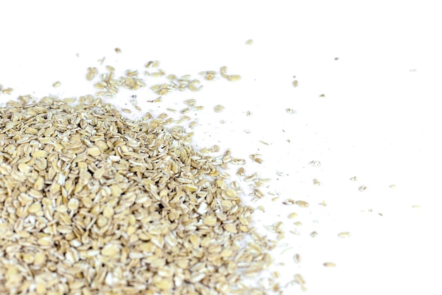 Scoop and pile of oatmeal with its unprocessed grains and plant.