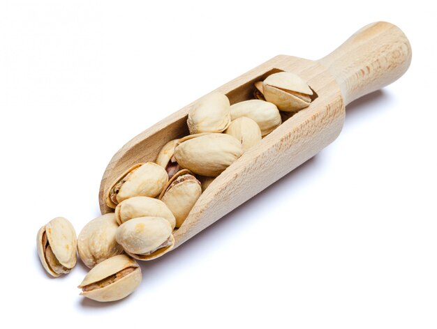 Scoop of Roasted pistachios nuts on white table