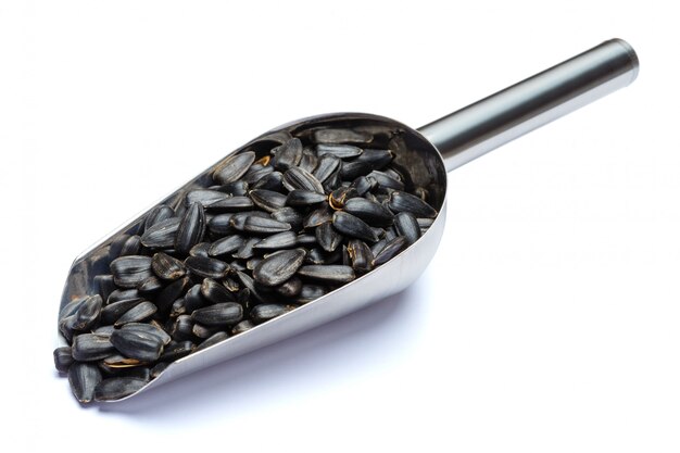 Scoop of sunflower seeds on a white table