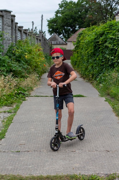 Scooter boy in baseball cap and sunglasses