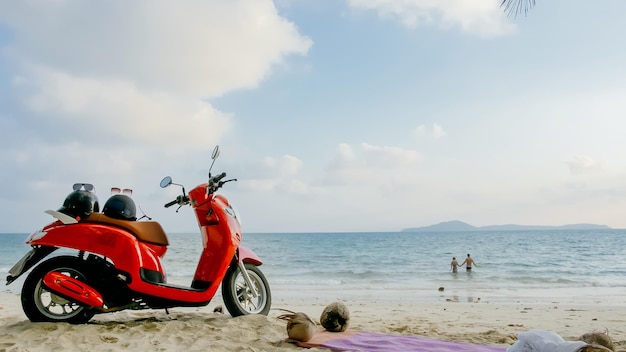 Scooter road trip. Lovely couple on red motorbike in white clothes on sand beach. Just married people kiss hugs walking near the tropical palm trees, sea. Wedding honeymoon by ocean. Motorcycle rent.