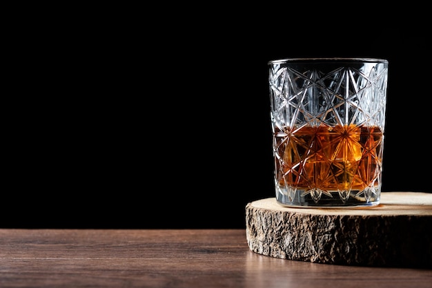 Foto bicchiere di whisky scozzese su tavola di legno