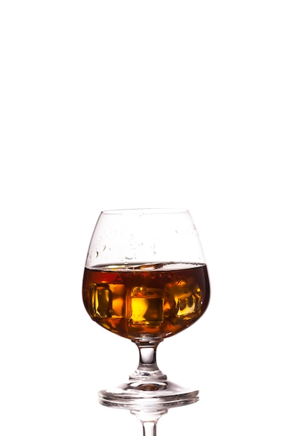 Photo scotch whiskey with ice in glass on table white background