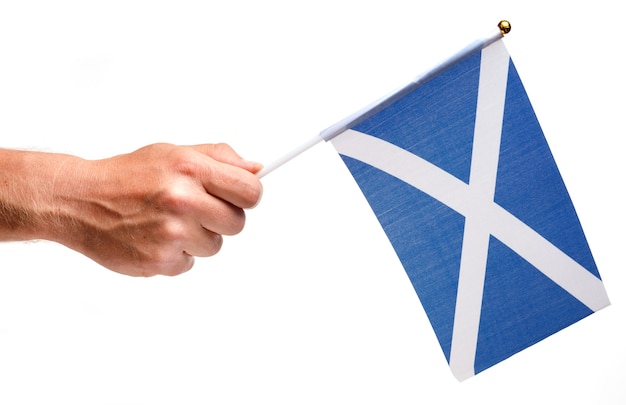 Изолировать небольшой флаг Шотландии в руке.