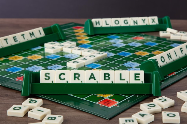 Scrabble Bordspel Woord Scrabble van lettertegels in tegelrek op spelbord