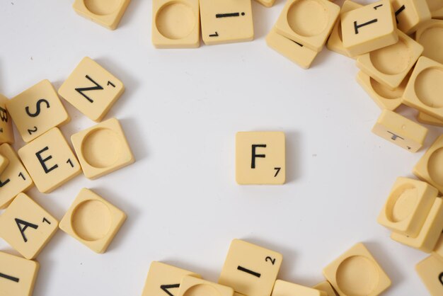 Scrabble lettera f vista dall'alto su sfondo bianco