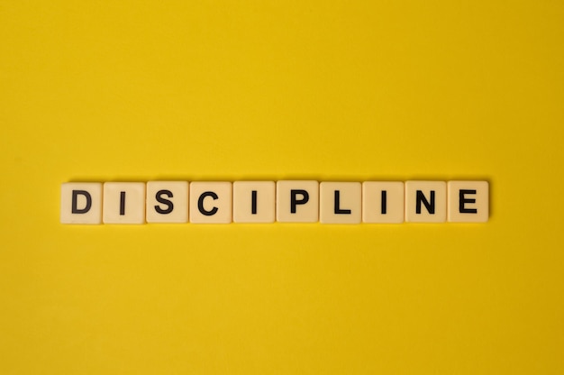 Scrabble letters with text discipline isolated on a yellow background