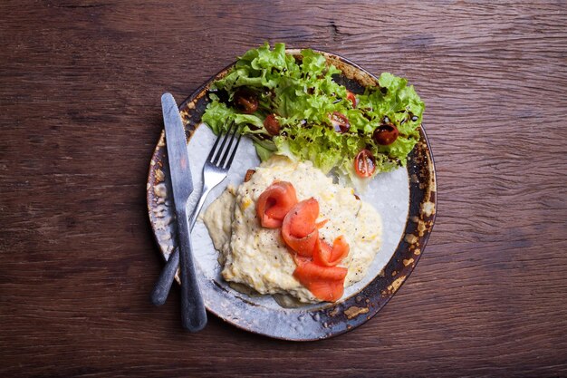 Scrambled egg and smoked salmon on wooden