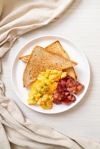 Scrambled egg with bread toasted and bacon