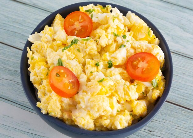 Scrambled eggs on bowl wooden table