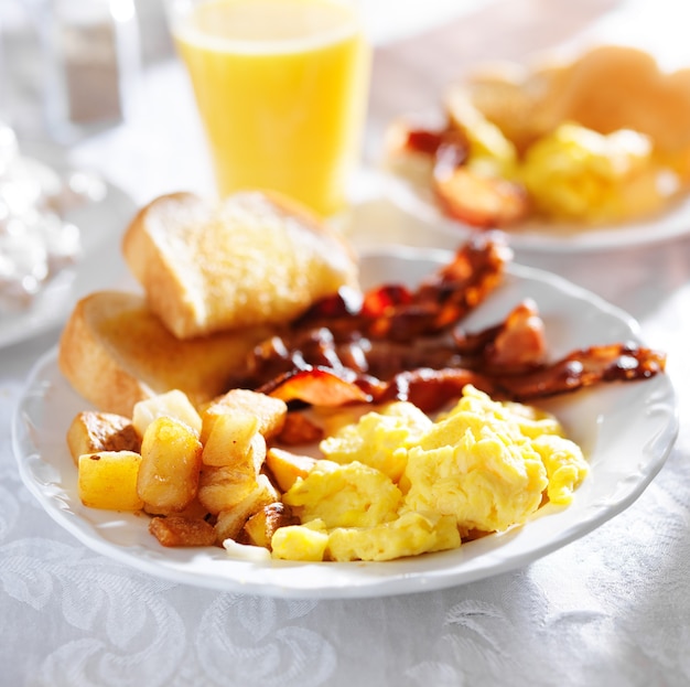 Scrambled eggs, fried potatoes and bacon