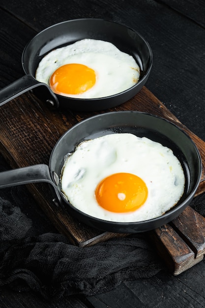 Scrambled eggs in frying pan with pork lard bread and green\
feathers in cast iron frying pan