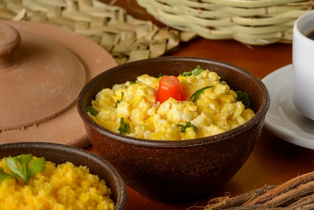 Scrambled eggs served in clay bowl.