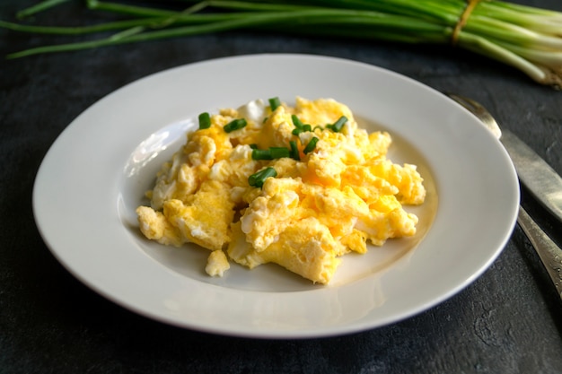 Scrambled eggs on a white plate. the view from the top.