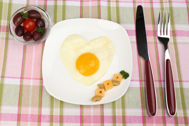 Scrambled eggs with bread on plate on color napkin