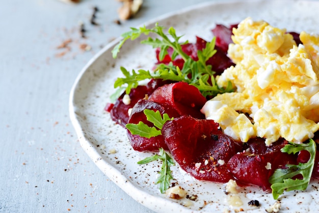 Scrambled eggs with carpaccio on a white plate