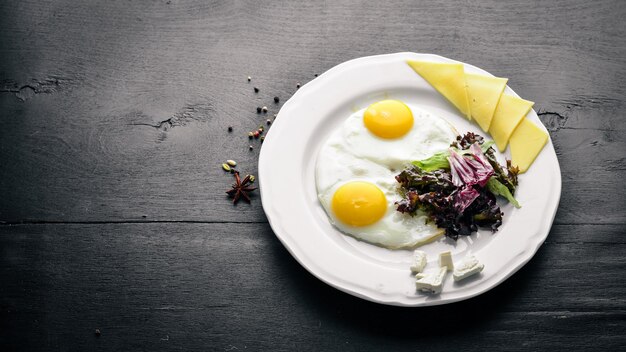 Scrambled eggs with cheese and herbs On a wooden background Top view Free space for text