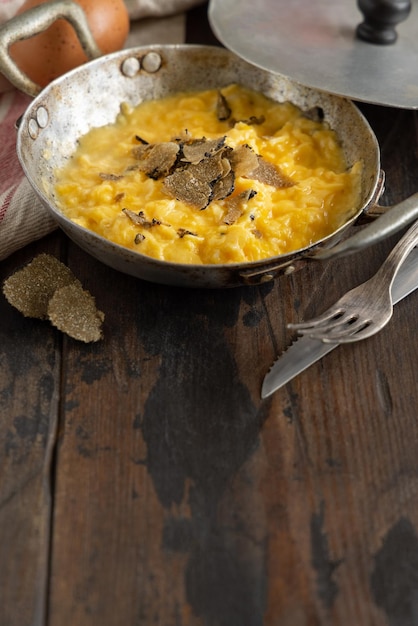 Scrambled eggs with fresh black truffles from Italy served in a frying pan close up copy space