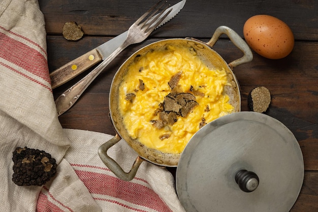 Scrambled eggs with fresh black truffles from Italy served in a frying pan gourmet breakfast
