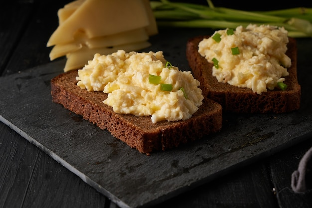 Scrambled eggs with green onion with gluten free bread on table