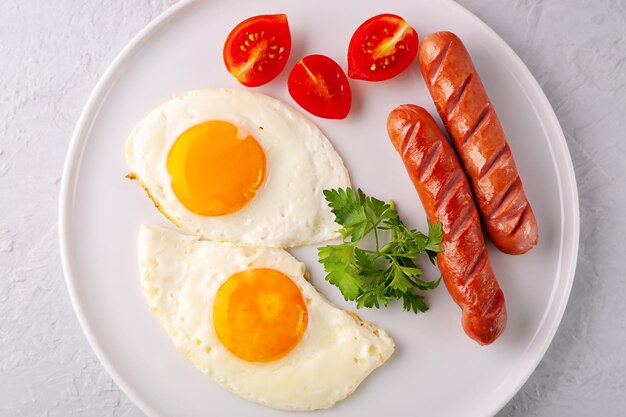 Scrambled eggs with grilled sausages and parsley and tomatoes