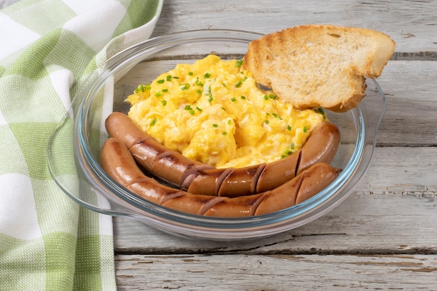 Scrambled eggs with sausages served on a plate