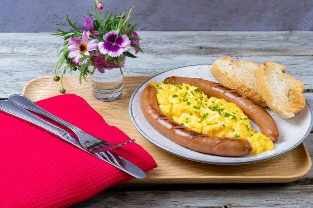 Scrambled eggs with sausages served on a plate