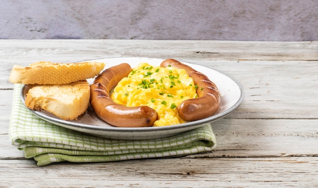 Scrambled eggs with sausages served on a plate